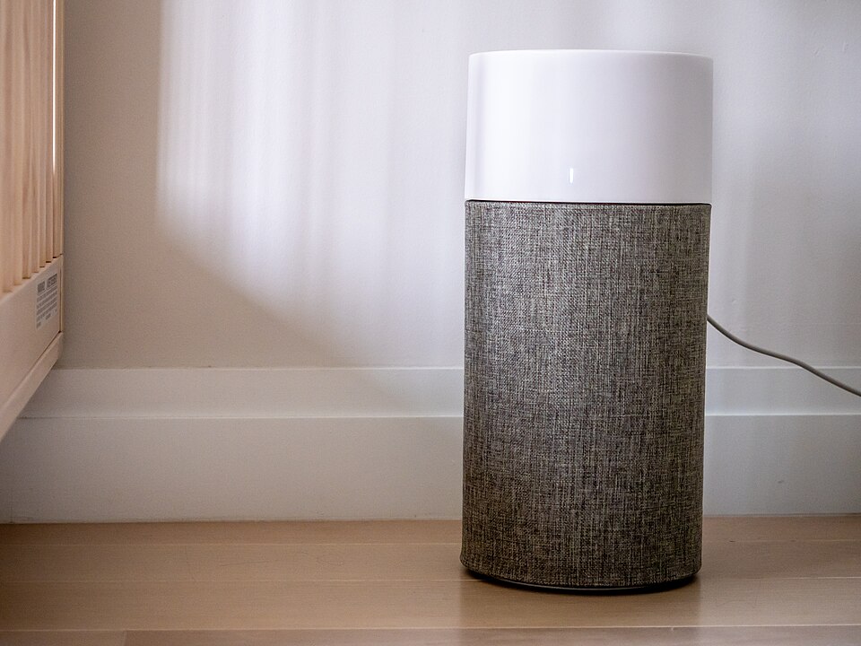 Modern cylindrical HEPA air purifier in minimalist living room setting